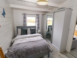 A bedroom with a bed and wardrobe at Nellies Log Cabin, Kilcogy