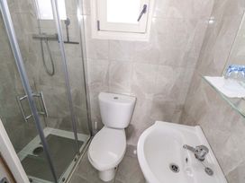 A bathroom with a shower, toilet, bidet, and sink at Nellies Log Cabin in Kilcogy