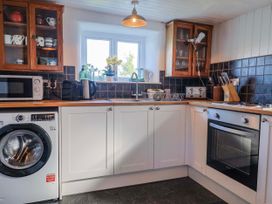 A kitchen with appliances including a washing machine and microwave at 2 Oak Tree Cottages Marshwood Nr. Hawkchurch