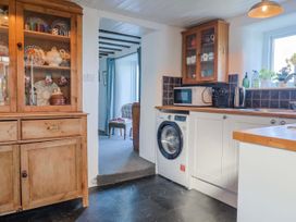 A kitchen with a washing machine and microwave at 2 Oak Tree Cottages Marshwood Nr. Hawkchurch