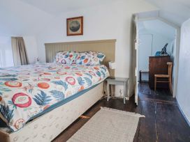 A bedroom with a bed and a nightstand at 2 Oak Tree Cottages Marshwood Nr. Hawkchurch