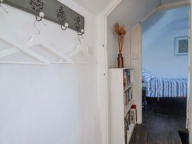 A hallway with a bookshelf and coat hooks at 2 Oak Tree Cottages Marshwood Nr. Hawkchurch