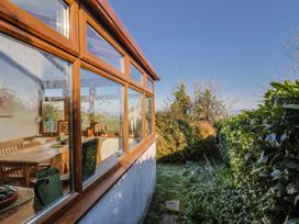A conservatory with a dining table and chairs at 2 Oak Tree Cottages Marshwood Nr. Hawkchurch