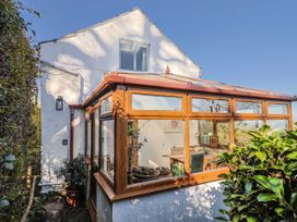 A conservatory with a table and chairs at 2 Oak Tree Cottages Marshwood Nr. Hawkchurch
