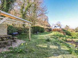 A garden with a bench and grill at 2 Oak Tree Cottages Marshwood Nr. Hawkchurch