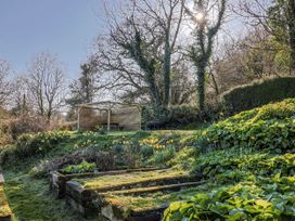 A garden with flowers and a patio structure at 2 Oak Tree Cottages Marshwood Nr. Hawkchurch