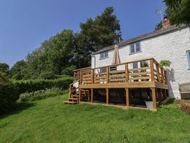 A house with a deck and stairs in the garden at 2 Oak Tree Cottages Marshwood Nr. Hawkchurch