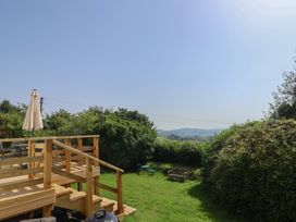 A garden with wooden steps and a parasol at 2 Oak Tree Cottages, Marshwood Nr. Hawkchurch