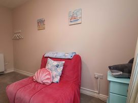 A bedroom with an armchair and a side table at Flat 1, 40 Hinderwell Lane