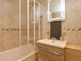 A bathroom featuring a shower, bathtub, and sink at Flat 1, 40 Hinderwell Lane