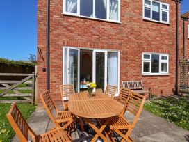 A garden with a table and chairs at Seashells at Runswick Lodge Runswick Bay