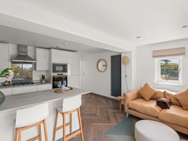 A kitchen with a sofa and bar stools at Capton Snug in Dartmouth