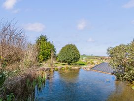A garden with a pond and trees at Capton Snug in Dartmouth
