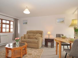 A living room with a sofa and dining table at Casa Mia in Porthpean near St Austell