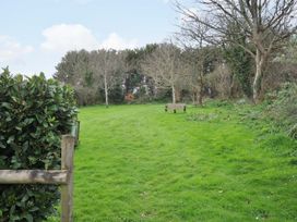 A garden with grass and a bench at Casa Mia in Porthpean near St Austell