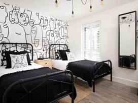 A bedroom with two beds and a mirror at Summerset Lodge