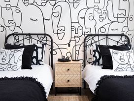 A bedroom with two beds and a patterned wall at Summerset Lodge