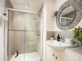 A bathroom with a shower, sink and mirror at Summerset Lodge in 