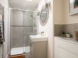 A bathroom with shower, wash basin, and storage at Summerset Lodge