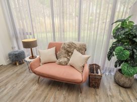 A living room with a sofa and plants at Summerset Lodge in Bamburgh