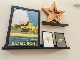 A shelf with framed art and decorative items at Summerset Lodge Bamburgh