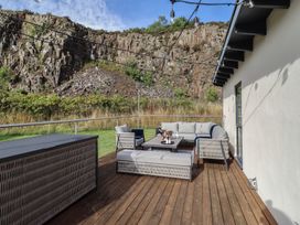 An outdoor seating area with furniture and a rock wall at Summerset Lodge in Bamburgh