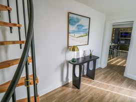 A hallway with a spiral staircase and a table with a lamp at An Tobar in Ballina