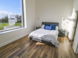A bedroom with a bed and nightstands at An Tobar in Ballina