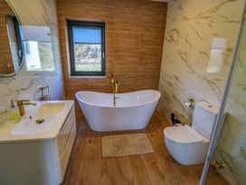 A bathroom with a bathtub, sink, and toilet at An Tobar in Ballina
