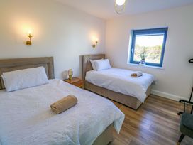 A bedroom with two beds and a window at An Tobar in Ballina