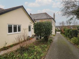 An outdoor view of a house with a pathway and bushes at Pump Cottage in Truro
