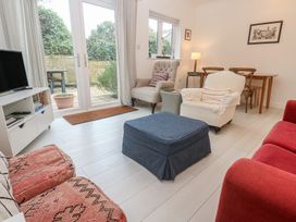 A living room with seating and a dining table at Pump Cottage in Truro