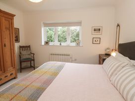 A bedroom with a bed, wardrobe, and window at Pump Cottage in Truro