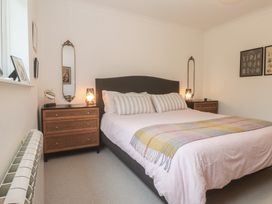 A bedroom with a bed and nightstands at Pump Cottage in Truro