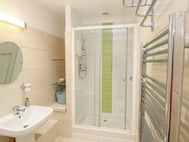 A bathroom with a shower, sink, and towel rail at Pump Cottage in Truro