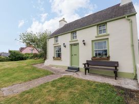 A cottage with a green door and bench at Beacon House in Marloes near Little Haven