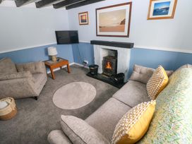A living room with a sofa and a fireplace at Beacon House Marloes near Little Haven