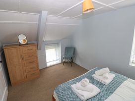 A bedroom with a bed and dresser at Beacon House Marloes near Little Haven