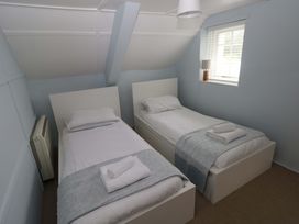 A bedroom with two beds and a lamp at Beacon House Marloes near Little Haven