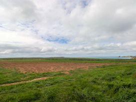 A field with grass and sea in the distance at Beacon House in Marloes near Little Haven