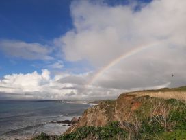 A coastal view with a rainbow over the ocean at Hope Cove in Kingsbridge