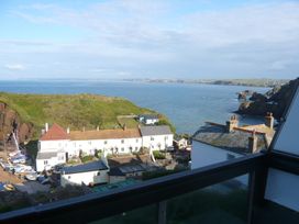 A view of the sea and coastline with buildings and boats at Hope Cove near Kingsbridge