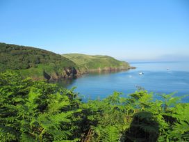 A coastal view with water, hills, and boats at Hope Cove near Kingsbridge