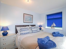 A bedroom with a bed and a lamp at Quay Sands, Hope Cove