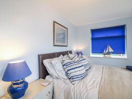 A bedroom with a bed and bedside table at Quay Sands, Hope Cove