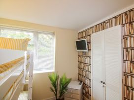 A bedroom with a bunk bed and a wall-mounted TV at Quay Sands, Hope Cove