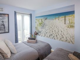 A bedroom with two beds and a beach mural at Quay Sands, Hope Cove
