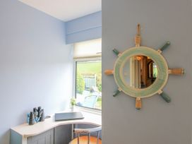 A desk with a laptop and a window at Quay Sands, Hope Cove
