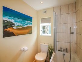 A bathroom with a bathtub and toilet at Quay Sands, Hope Cove