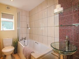 A bathroom with bathtub, toilet and sink at Quay Sands, Hope Cove